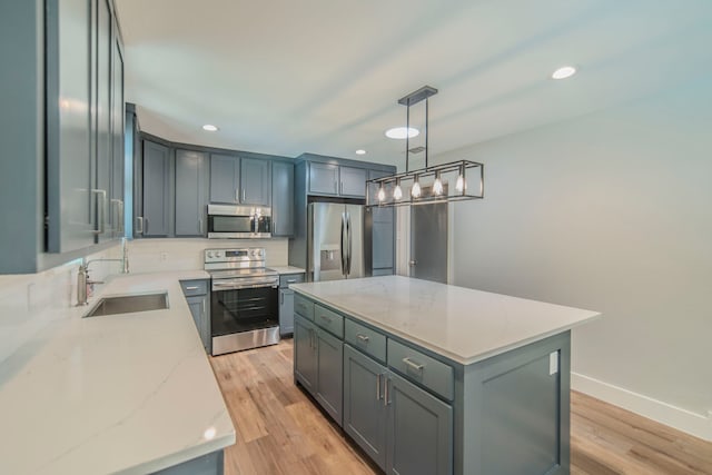5209 Cordova Ave, Fort Worth, TX 76132 - kitchen featuring appliances with stainless steel finishes, a center island, light wood-style flooring, recessed lighting, and light stone counters
