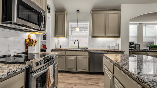 602 Franklin Ln, Lavon, TX 75166 - kitchen featuring stainless steel appliances, gray cabinetry, arched walkways, and backsplash