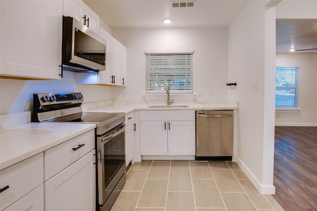 431 S Locust St, Mesquite, TX 75149 - kitchen with appliances with stainless steel finishes, light stone counters, white cabinets, light tile patterned floors, and recessed lighting