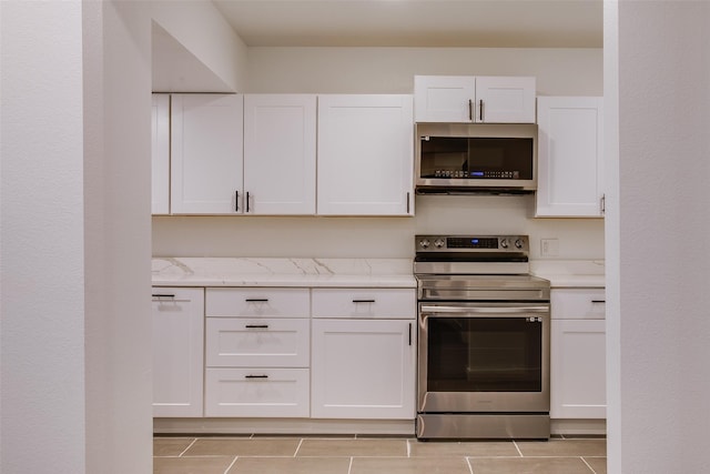 431 S Locust St, Mesquite, TX 75149 - kitchen with stainless steel appliances, white cabinets, light tile patterned floors, and light stone counters