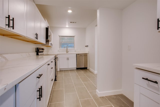 431 S Locust St, Mesquite, TX 75149 - kitchen featuring appliances with stainless steel finishes, light stone countertops, white cabinetry, recessed lighting, and light tile patterned floors