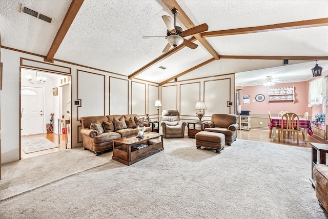 821 Sandpiper Dr, Denton, TX 76205 - living area featuring a ceiling fan, a textured ceiling, a decorative wall, light colored carpet, and a chandelier