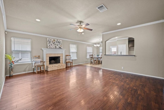 9444 Centennial Dr, Waco, TX 76708 - living area featuring ceiling fan, wood finished floors, a stone fireplace, ornamental molding, and a textured ceiling