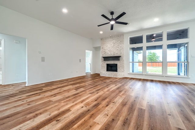 123 Rolling Spring Dr, Aledo, TX 76008 - unfurnished living room featuring a ceiling fan, a stone fireplace, wood finished floors, and recessed lighting