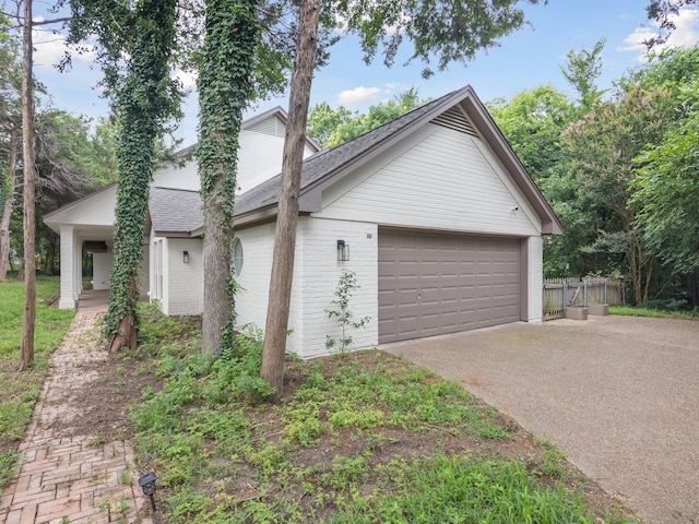 915 Slippery Elm Dr, Ovilla, TX 75154 - view of side of home with concrete driveway, a garage, roof with shingles, and brick siding