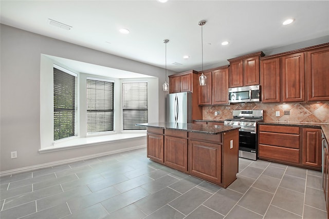 1511 Biltmore Ln, Irving, TX 75063 - kitchen with stainless steel appliances, a center island, tasteful backsplash, dark stone countertops, and tile patterned flooring