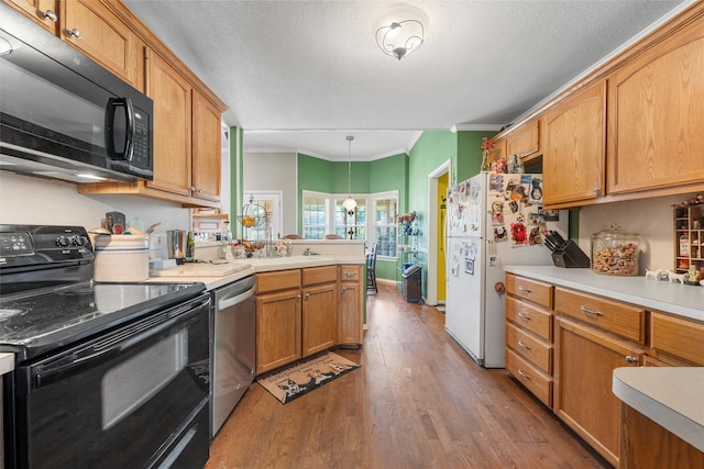 705 Tahoe Trail Dr, Hewitt, TX 76643 - kitchen with black appliances, wood finished floors, ornamental molding, a peninsula, and light countertops