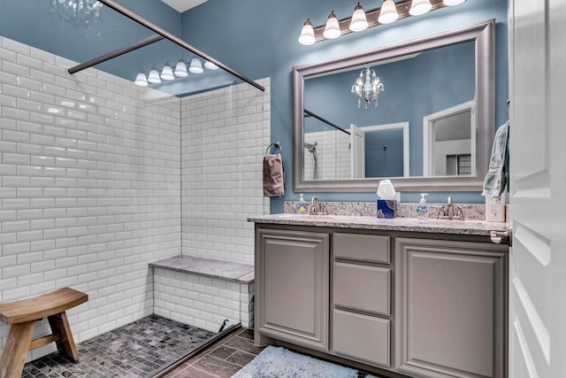 108 Gateway Dr, Alvarado, TX 76009 - bathroom featuring a tile shower, double vanity, and a chandelier