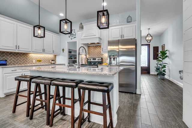108 Gateway Dr, Alvarado, TX 76009 - kitchen with appliances with stainless steel finishes, wood finished floors, white cabinetry, decorative backsplash, and recessed lighting