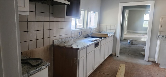 940 W 7th St, Dallas, TX 75208 - kitchen with range hood, white cabinetry, light countertops, and tasteful backsplash