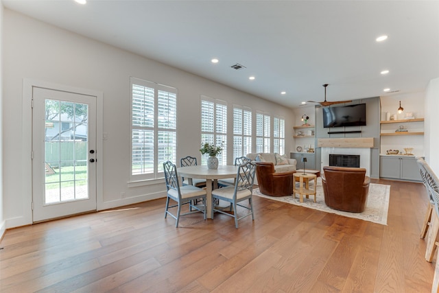 4508 Crystal Mountain Dr, Richardson, TX 75082 - dining area with a fireplace, plenty of natural light, light wood-type flooring, ceiling fan, and recessed lighting