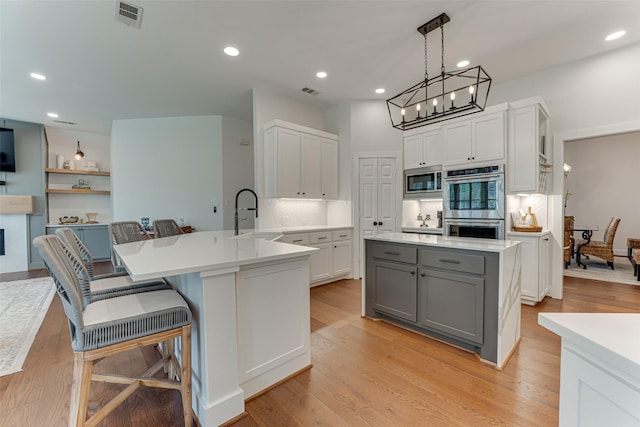 4508 Crystal Mountain Dr, Richardson, TX 75082 - kitchen with appliances with stainless steel finishes, gray cabinetry, tasteful backsplash, a peninsula, and light countertops