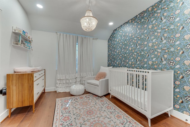 4508 Crystal Mountain Dr, Richardson, TX 75082 - bedroom with wallpapered walls, wood finished floors, a chandelier, recessed lighting, and a crib