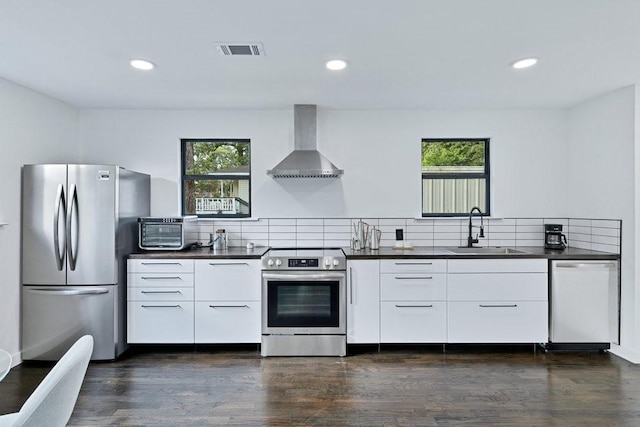 1104 Holiday Dr, Tool, TX 75143 - kitchen featuring appliances with stainless steel finishes, wall chimney exhaust hood, modern cabinets, dark countertops, and recessed lighting