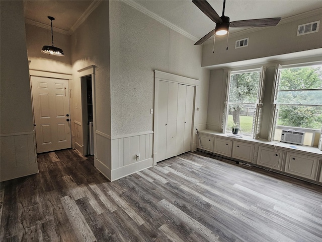 210 E Navasota St, Groesbeck, TX 76642 - unfurnished bedroom featuring cooling unit, crown molding, a textured wall, wood finished floors, and high vaulted ceiling