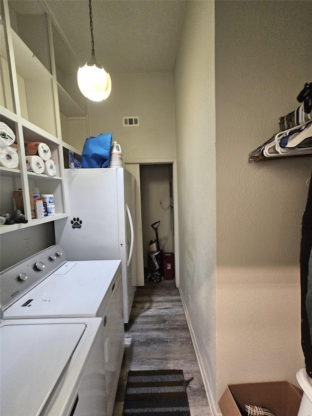 210 E Navasota St, Groesbeck, TX 76642 - laundry area with independent washer and dryer, dark wood-style floors, and a textured wall