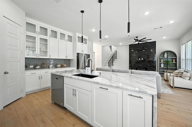 1338 E Kiest Blvd, Dallas, TX 75216 - kitchen featuring stainless steel appliances, open floor plan, light wood-style floors, ceiling fan, and a center island with sink