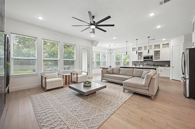 1338 E Kiest Blvd, Dallas, TX 75216 - living room featuring a ceiling fan, light wood finished floors, recessed lighting, and a chandelier