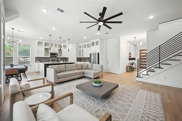 1338 E Kiest Blvd, Dallas, TX 75216 - living room featuring a chandelier, light wood-type flooring, stairs, ceiling fan, and recessed lighting