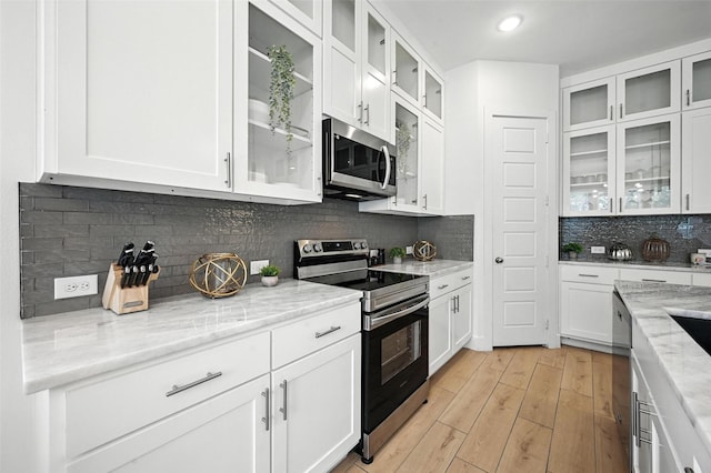 1338 E Kiest Blvd, Dallas, TX 75216 - kitchen featuring appliances with stainless steel finishes, tasteful backsplash, white cabinetry, light wood-style floors, and recessed lighting
