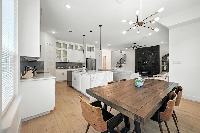 1338 E Kiest Blvd, Dallas, TX 75216 - dining room featuring a chandelier, light wood-style floors, recessed lighting, stairway, and a fireplace