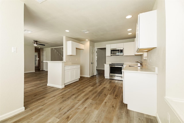 813 Ridgemont Dr, Allen, TX 75002 - kitchen with appliances with stainless steel finishes, a ceiling fan, recessed lighting, white cabinets, and light wood-style flooring