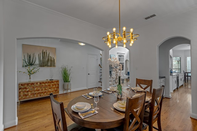 2248 Forest Hollow Park, Dallas, TX 75228 - dining room featuring light wood finished floors, ornamental molding, arched walkways, and a chandelier