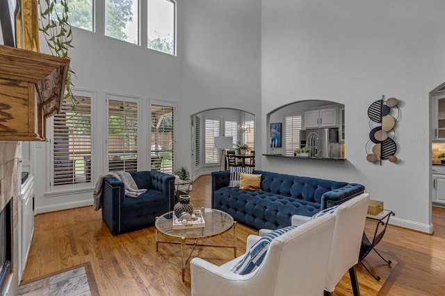 2248 Forest Hollow Park, Dallas, TX 75228 - living room with light wood finished floors, a high ceiling, a premium fireplace, and arched walkways