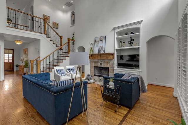 2248 Forest Hollow Park, Dallas, TX 75228 - living area with a high ceiling, a fireplace, wood finished floors, arched walkways, and built in features