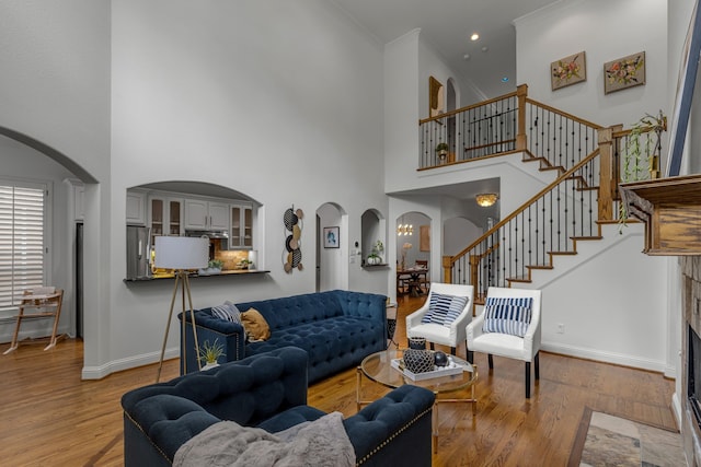 2248 Forest Hollow Park, Dallas, TX 75228 - living room with arched walkways, wood finished floors, a high ceiling, stairs, and ornamental molding