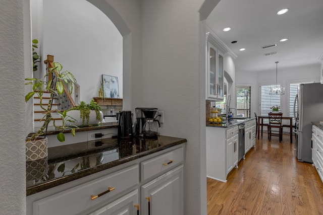 2248 Forest Hollow Park, Dallas, TX 75228 - kitchen with arched walkways, white cabinets, recessed lighting, light wood-style floors, and stainless steel appliances