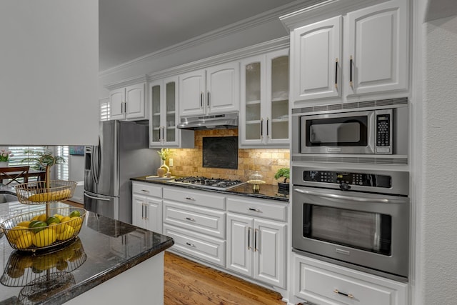 2248 Forest Hollow Park, Dallas, TX 75228 - kitchen with appliances with stainless steel finishes, under cabinet range hood, ornamental molding, decorative backsplash, and glass insert cabinets