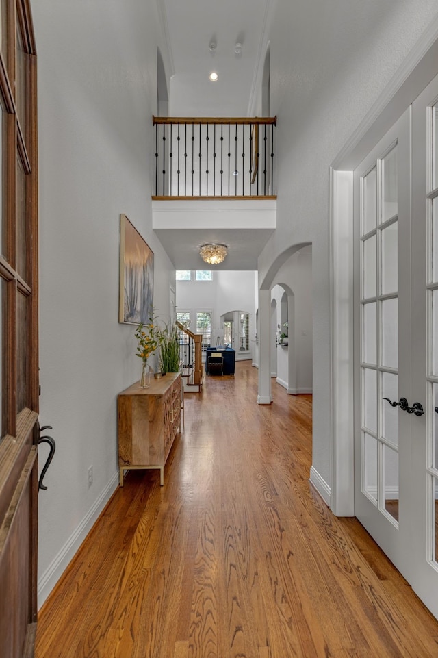 2248 Forest Hollow Park, Dallas, TX 75228 - entrance foyer with arched walkways, a towering ceiling, light wood-style flooring, french doors, and ornamental molding
