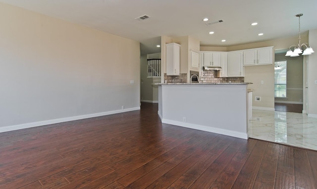 2505 Hunters Run Dr, Plano, TX 75025 - kitchen featuring under cabinet range hood, hardwood / wood-style flooring, white cabinets, light stone counters, and recessed lighting