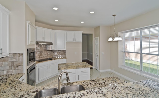 2505 Hunters Run Dr, Plano, TX 75025 - kitchen featuring under cabinet range hood, appliances with stainless steel finishes, healthy amount of natural light, light marble finish flooring, and recessed lighting