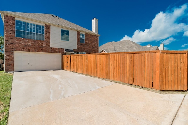 2505 Hunters Run Dr, Plano, TX 75025 - view of home's exterior featuring concrete driveway, an attached garage, a chimney, and brick siding