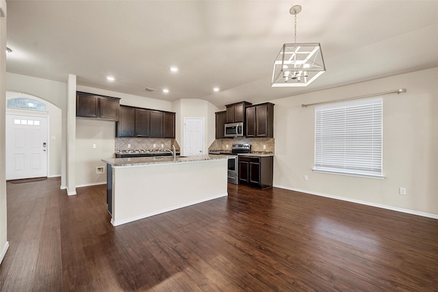 3217 Beutel Rd, Lorena, TX 76655 - kitchen featuring appliances with stainless steel finishes, tasteful backsplash, dark brown cabinets, a kitchen island with sink, and recessed lighting