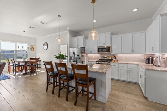 6105 Parma Ln, Temple, TX 76502 - kitchen with stainless steel appliances, tasteful backsplash, ornamental molding, white cabinets, and an island with sink