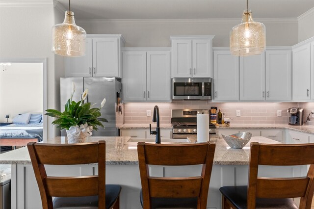 6105 Parma Ln, Temple, TX 76502 - kitchen with appliances with stainless steel finishes, tasteful backsplash, white cabinetry, and crown molding