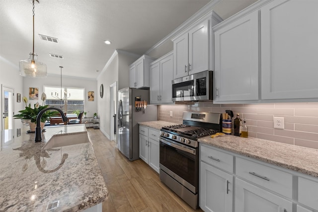 6105 Parma Ln, Temple, TX 76502 - kitchen with appliances with stainless steel finishes, ornamental molding, tasteful backsplash, decorative light fixtures, and a chandelier