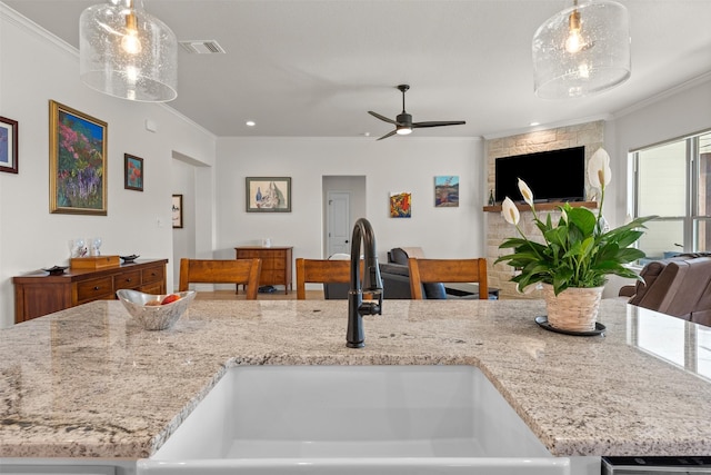6105 Parma Ln, Temple, TX 76502 - kitchen featuring open floor plan, ornamental molding, decorative light fixtures, light stone counters, and ceiling fan