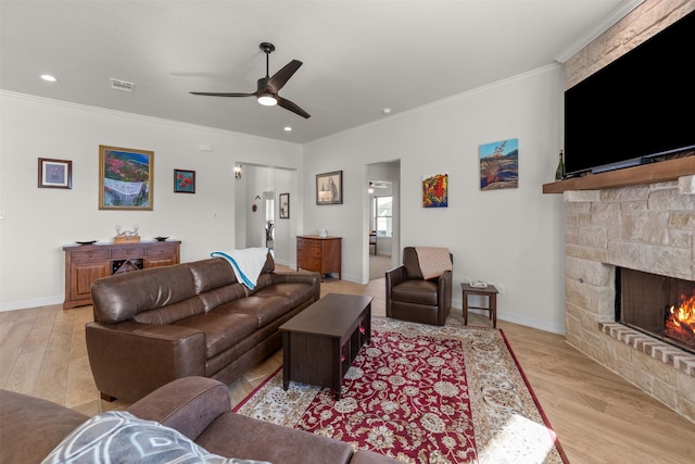 6105 Parma Ln, Temple, TX 76502 - living room featuring ceiling fan, crown molding, a fireplace, light wood-style flooring, and recessed lighting