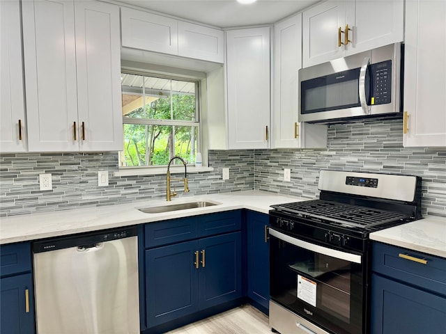 3633 Flamingo Way, Mesquite, TX 75150 - kitchen with appliances with stainless steel finishes, blue cabinets, white cabinetry, and backsplash