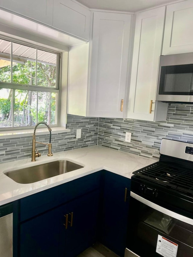 3633 Flamingo Way, Mesquite, TX 75150 - kitchen with range with gas cooktop, stainless steel microwave, backsplash, white cabinetry, and light stone counters