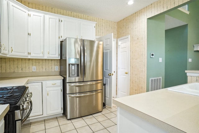 448 Shade Tree Cir, Hurst, TX 76054 - kitchen featuring appliances with stainless steel finishes, white cabinetry, light countertops, light tile patterned flooring, and wallpapered walls