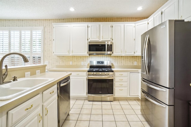 448 Shade Tree Cir, Hurst, TX 76054 - kitchen featuring appliances with stainless steel finishes, light countertops, white cabinetry, recessed lighting, and a textured ceiling