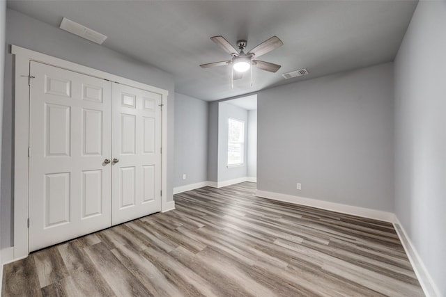 606 E 12th St, Bonham, TX 75418 - unfurnished bedroom with wood finished floors, a closet, and a ceiling fan