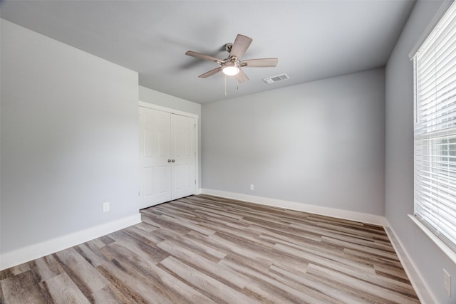606 E 12th St, Bonham, TX 75418 - unfurnished bedroom with wood finished floors, a closet, and ceiling fan