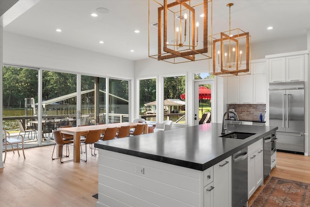 548 Winding Ln, Mount Vernon, TX 75457 - kitchen featuring built in fridge, dark countertops, healthy amount of natural light, light wood-type flooring, and recessed lighting