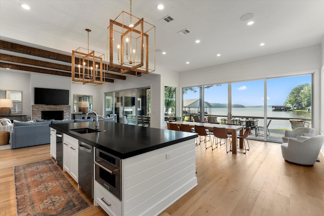 548 Winding Ln, Mount Vernon, TX 75457 - kitchen featuring dark countertops, open floor plan, a chandelier, light wood-style flooring, and white cabinetry